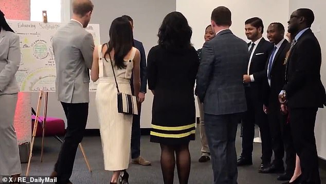 A screengrab from the video clip shows the moment before Harry and Meghan both step forward to shake hands with a man opposite them