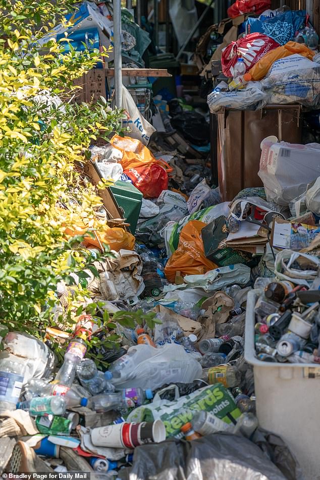 Oozing mountains of rubbish are piled up in the front drive and garden of the crumbling home