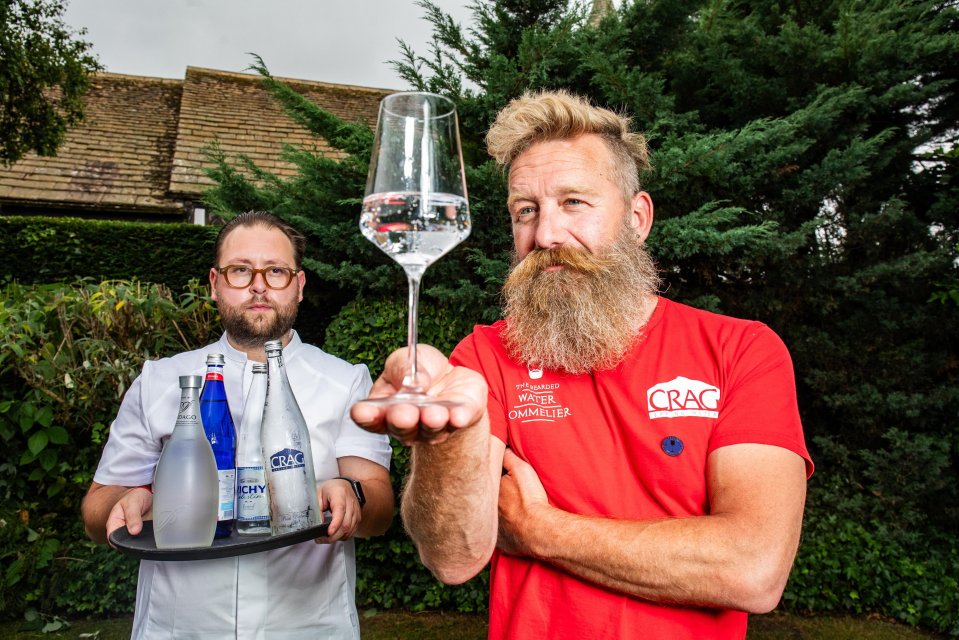 Chef and sommelier presenting bottled water menu.