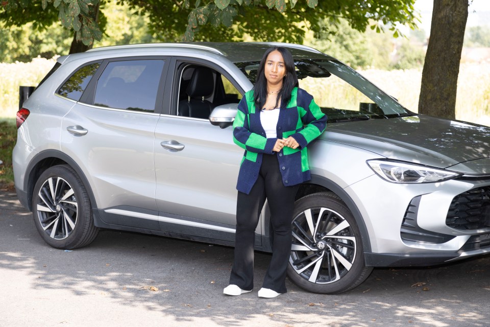 Simone Baron standing next to a silver SUV.