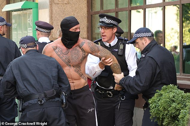 Several men - one of them masked and topless - were seen being detained by police following a string of arrests made in recent weeks