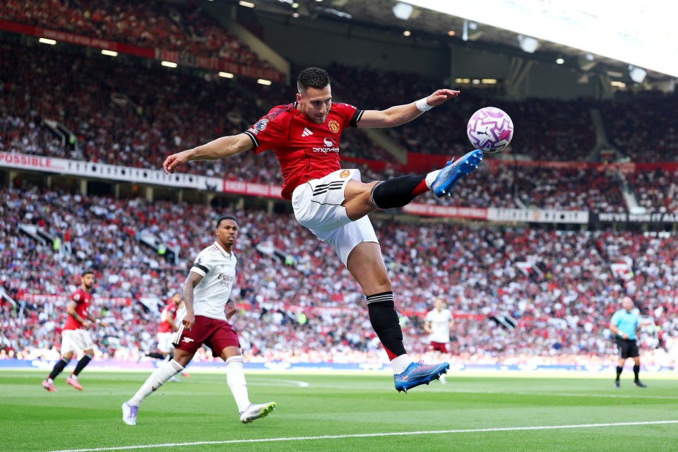 Diogo Dalot of Manchester United kicking a soccer ball during a game.