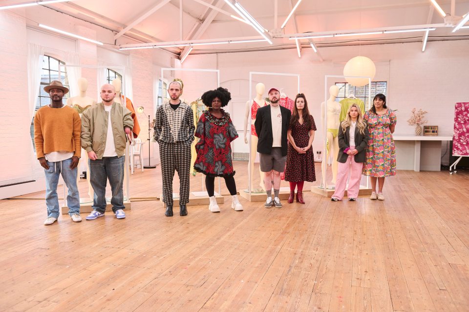 Eight contestants standing in a line in a design studio.