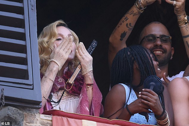 Madonna blew kisses to fans who spotted the pop icon as she watched from a balcony