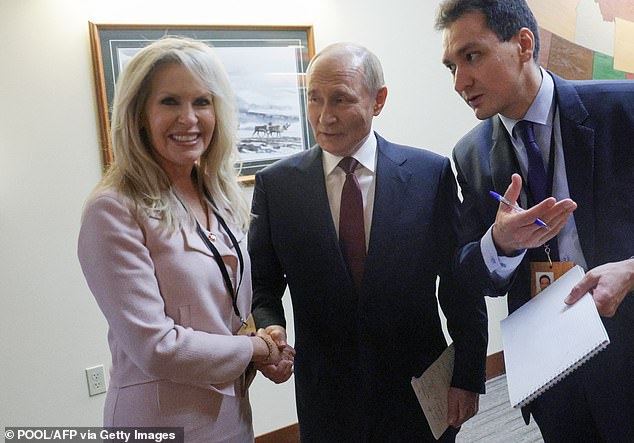 Russian President Vladimir Putin shakes hands with US Chief of Protocol Monica Crowley in Anchorage on Friday, in a pool photograph distributed by the Russian state agency Sputnik