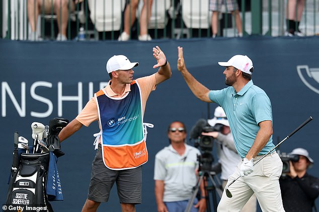 Scheffler celebrates with his caddie after he sent the fans in attendance wild with the shot