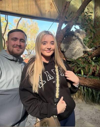 Couple posing with a koala.