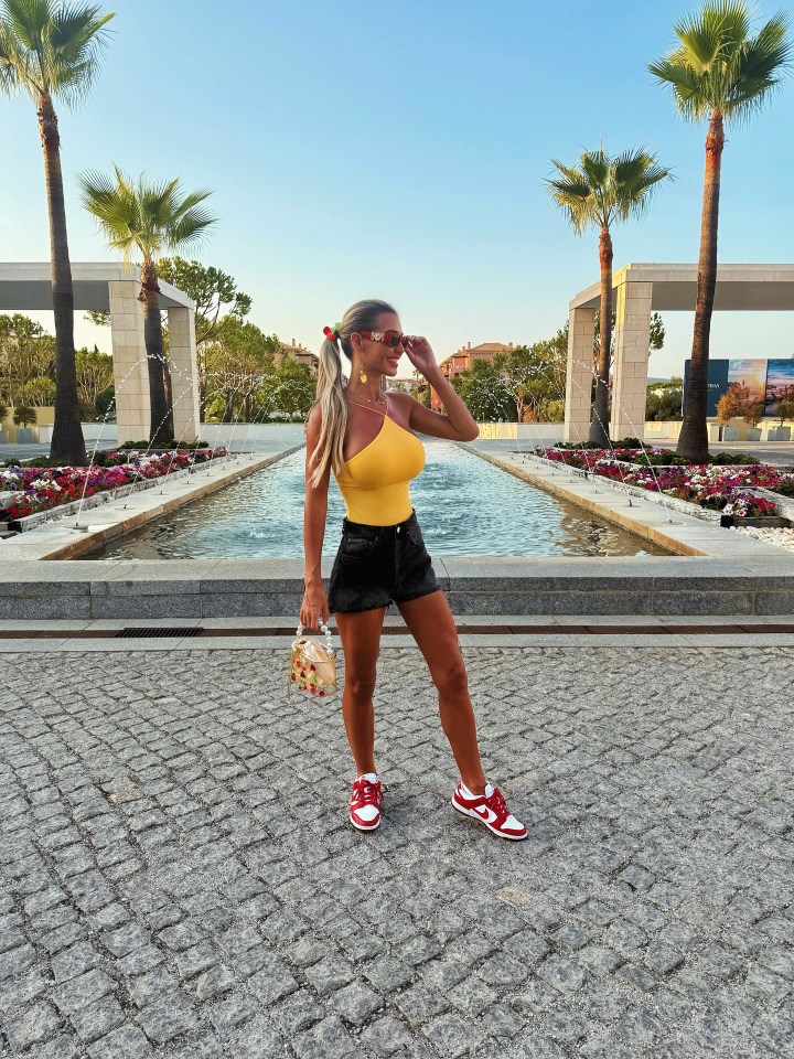 Christine McGuinness showing off her tan in a yellow top and denim shorts.