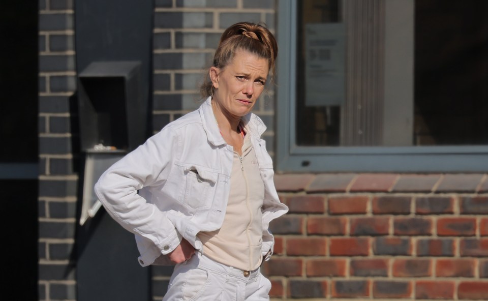 Woman in white jacket appearing in court.