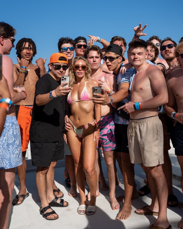 Bonnie Blue in a bikini with a group of people taking a selfie.