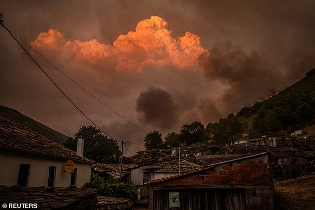 A cloud forms as smoke rises from a wildfire behind the village of Vilarmel, Lugo area, Galicia region, Spain, August 16, 2025
