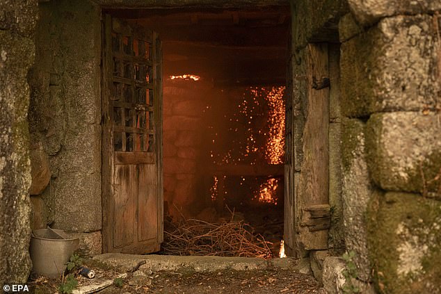 A house burns due to the forest fire in Carballeda de Avia, Ourense, Galicia, north-western Spain, 17 August 2025