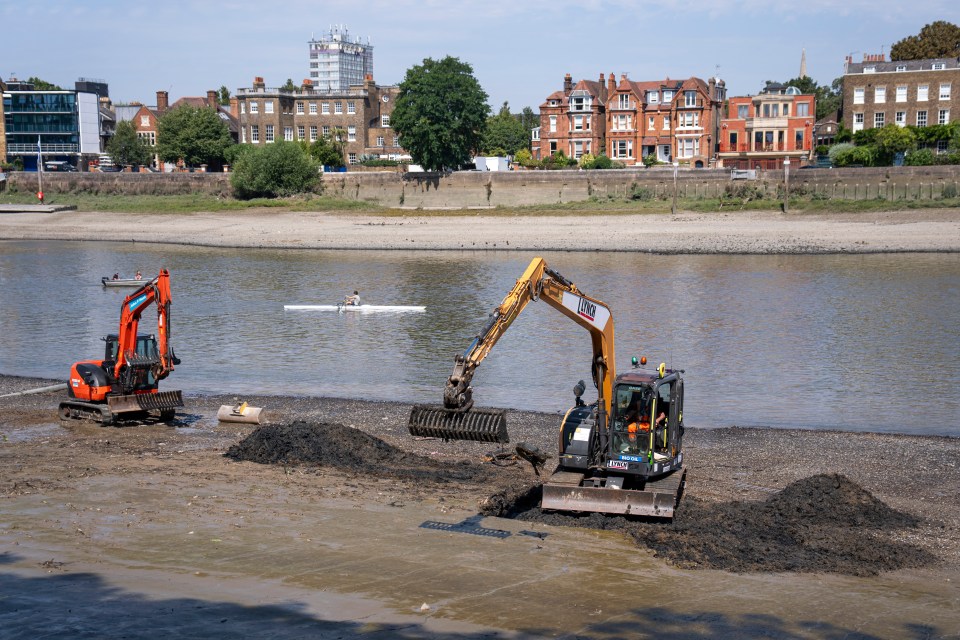 Construction workers removing wet wipes from a riverbank.