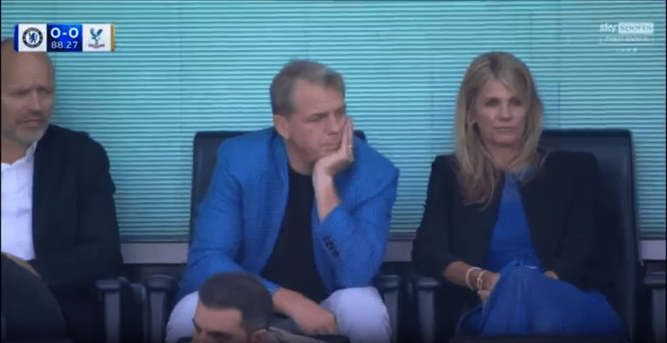 Screenshot of a man and woman seated, appearing to watch a sporting event.