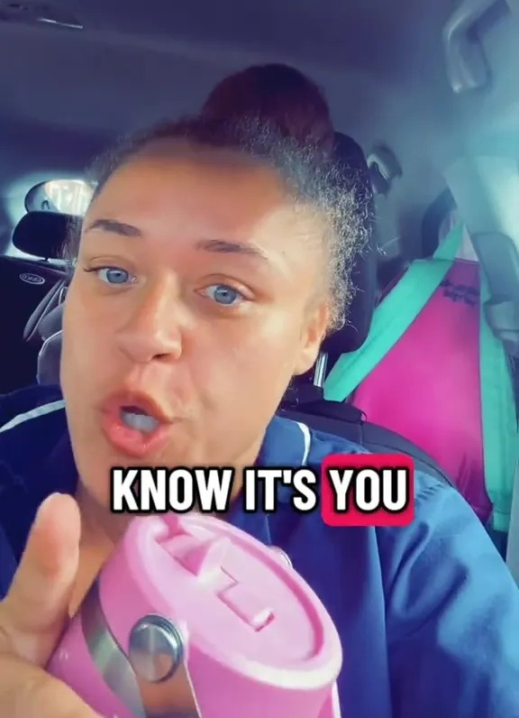 Screenshot of a woman in a car, holding a pink travel mug, and saying "KNOW IT'S YOU."