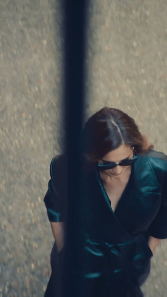 Cheryl in a dark green dress and sunglasses.