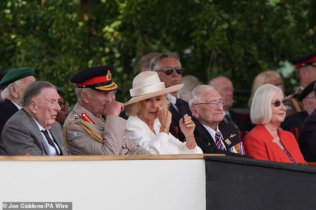 King Charles III and Queen Camilla react to veteran Yavar Abbas's reference to the King's cancer treatment during the VJ Day service at the National Memorial Arboretum on Friday