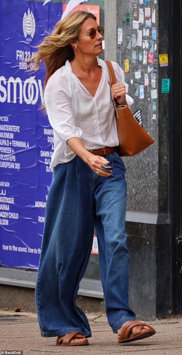 The stunner shielded her eyes behind gold rimmed aviator shades and accessorised with tan sandals and a matching handbag
