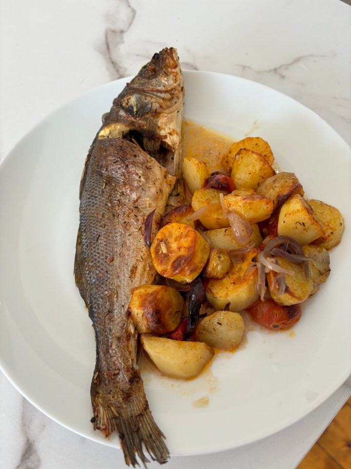 Roasted fish with roasted potatoes and tomatoes.