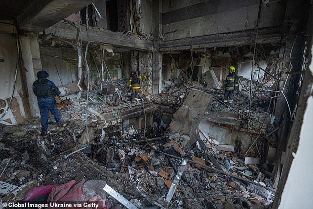 Rescuers clear the rubble in a destroyed apartment building after a Russian drone attack on Kharkiv, Ukraine