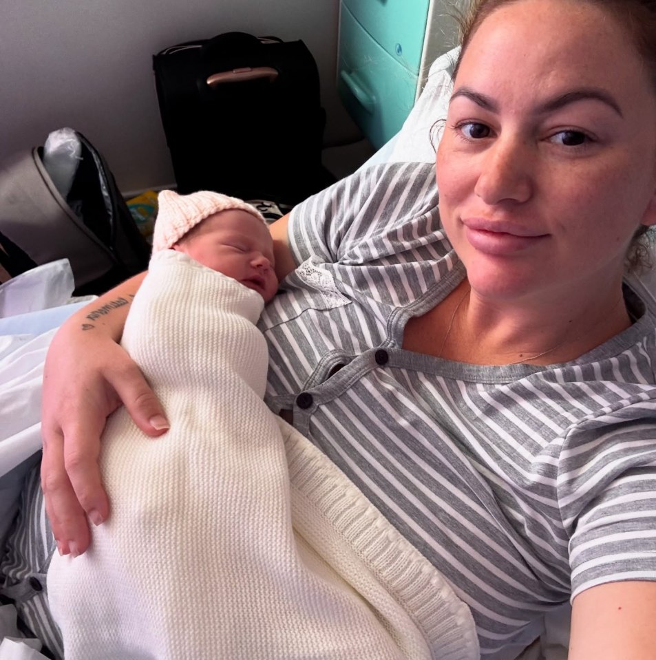 Mother holding her newborn baby in a hospital bed.