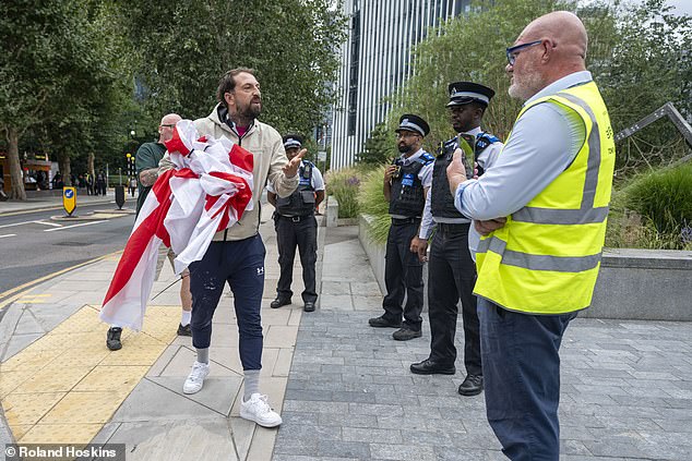 Downing Street on Sunday backed the flying of the national flags, although stopped short of commenting on individual cases such as the disputes in Birmingham and Tower Hamlets. Pictured: A local man remonstrates with council officers over the taking down of flags in Tower Hamlets