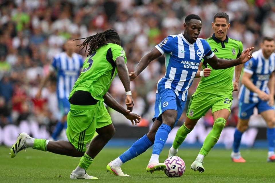 Danny Welbeck of Brighton running past Calvin Bassey of Fulham during a soccer match.