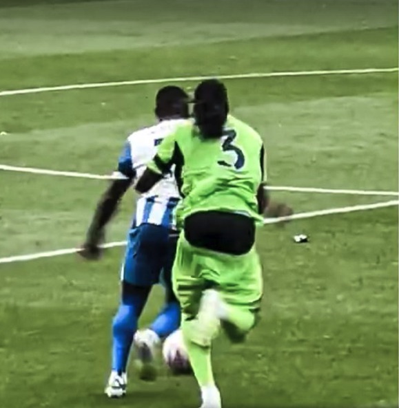 Soccer players contesting the ball.