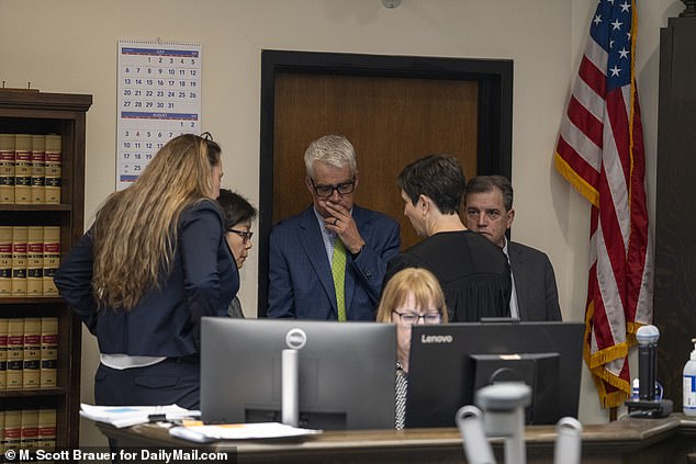 The lawyers huddle in a sidebar with Judge Schaller during the trial