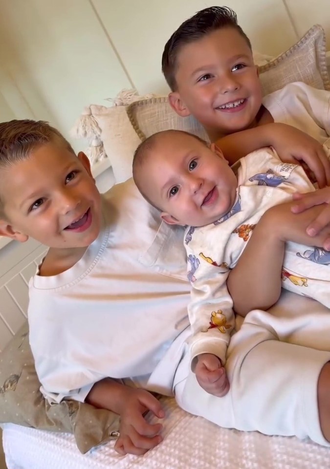 Three young boys cuddling together.