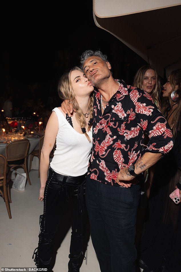 Cara Delevingne cut a casual figure in a white vest which she wore with black trousers and a matching belt