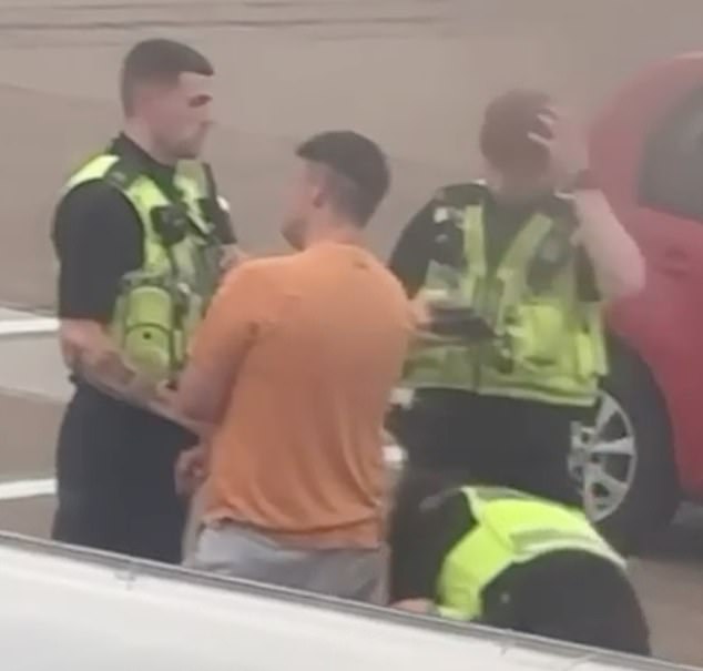 Another clip taken through a window of the plane showed the man talking to three officers on the tarmac as one appeared to search him