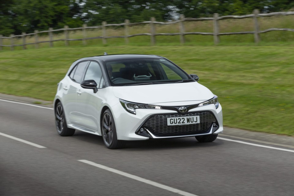 Toyota Corolla driving on a road.