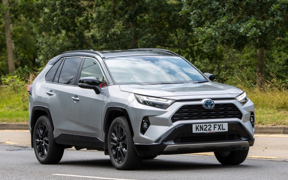 Silver 2022 Toyota RAV4 hybrid driving on a road.