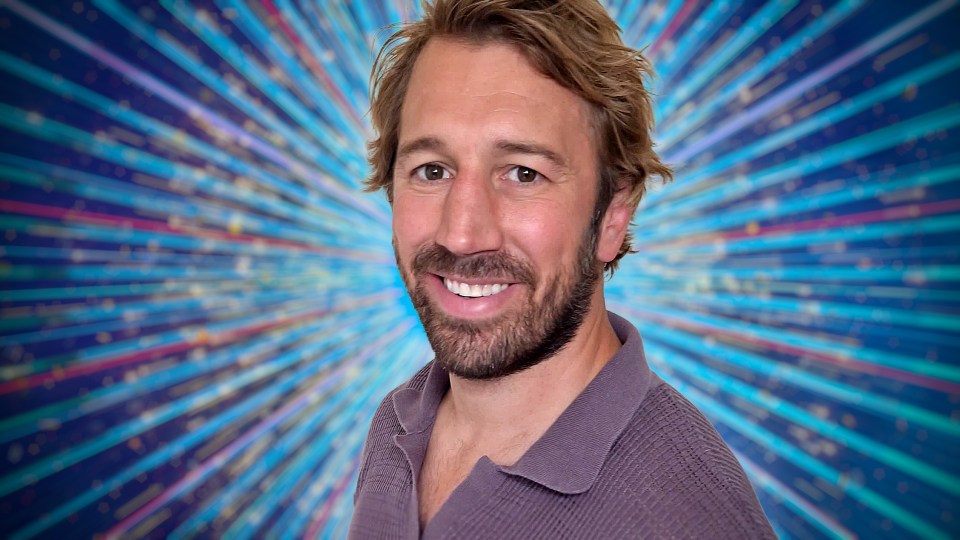 Headshot of a smiling man against a sparkly background.