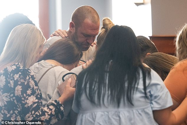 Outside, he was comforted by supporters wearing gray 'I Stand with Sarah Grace' T-shirts, who formed a prayer circle around him