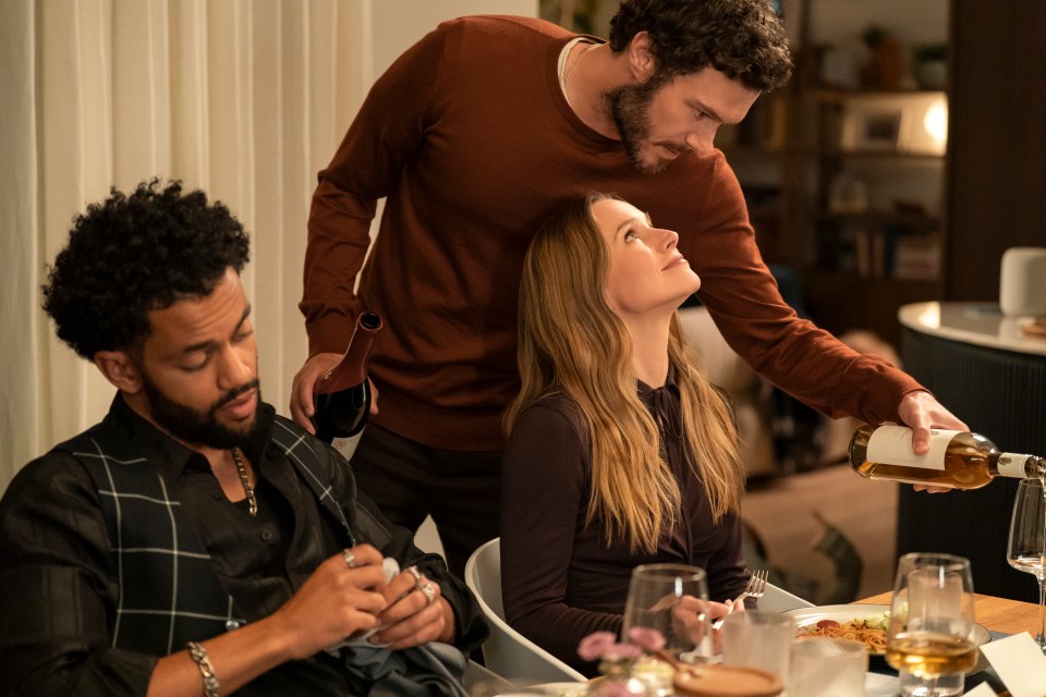 Scene from *Nobody Wants This* showing Miles Fowler, Adam Brody, and Kristen Bell at a dinner table.