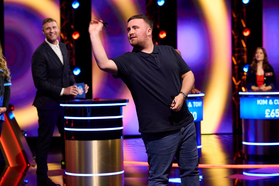 Contestant throwing a dart on a game show.