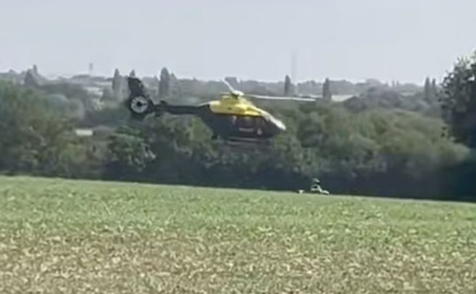 Helicopter flying low over a field.