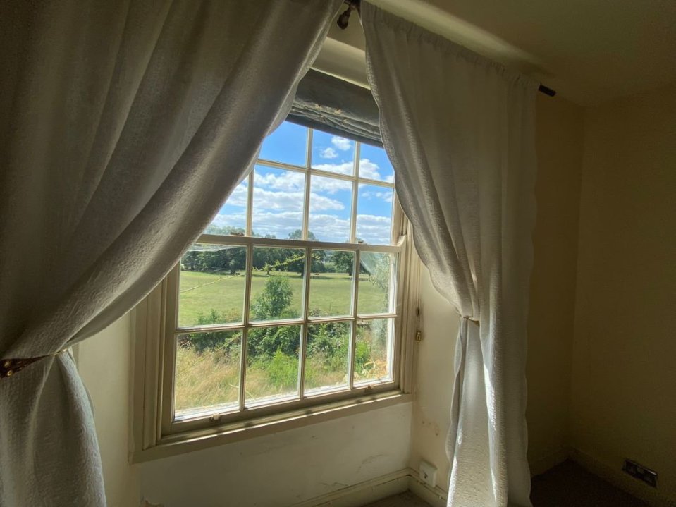 View from a farmhouse window in Devon, showing a grassy field.