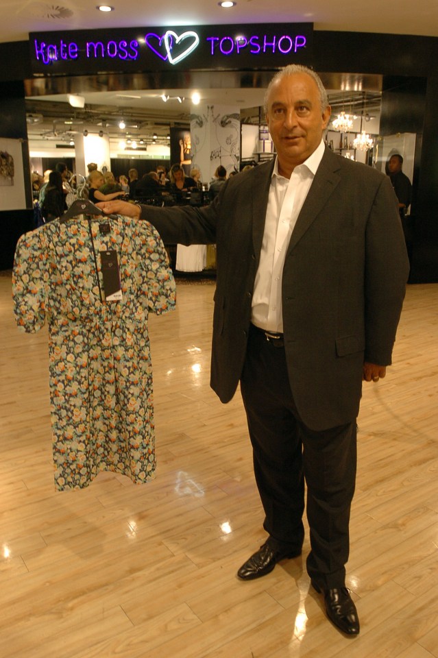 Philip Green holding a floral dress in a Topshop store.