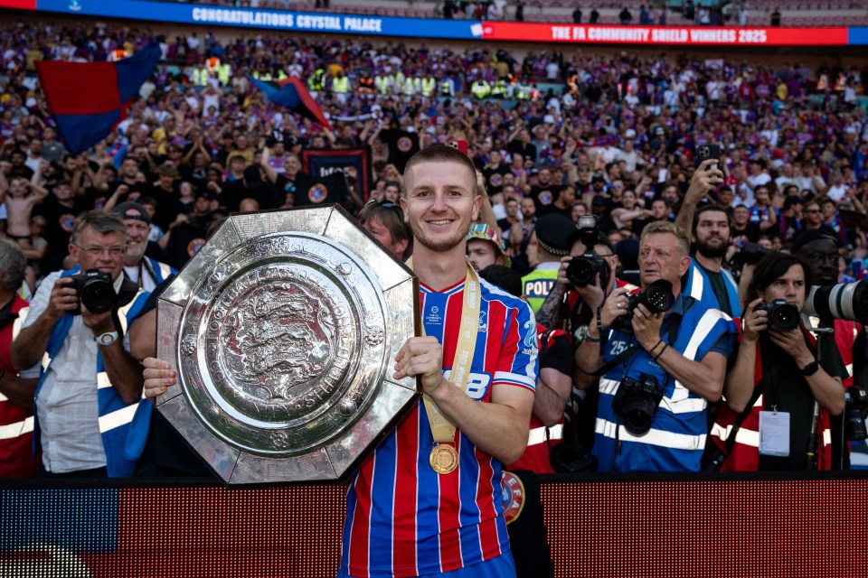 Adam Wharton of Crystal Palace holding the FA Community Shield trophy.