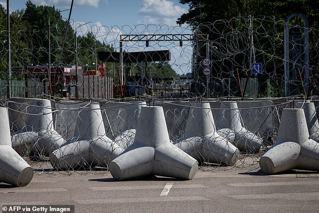 The Polish-Belarusian country border crossing is seen behind concrete anti-tank obstacles and barbed wire in Polowce-Pieszczatka, Poland on July 21, 2025,