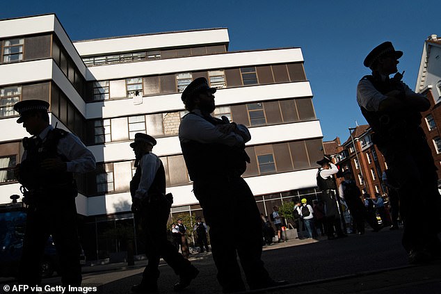 Police officers stand outside the Thistle City Barbican hotel, in London on August 8, 2025, ahead of an expected protest