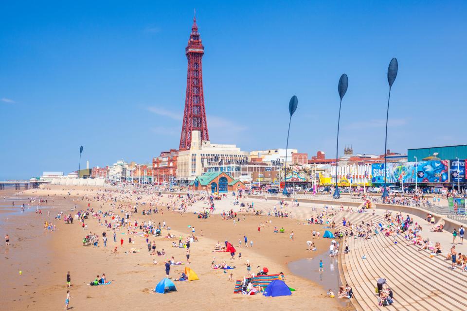 Crowded Blackpool beach with the Blackpool Tower in the background.