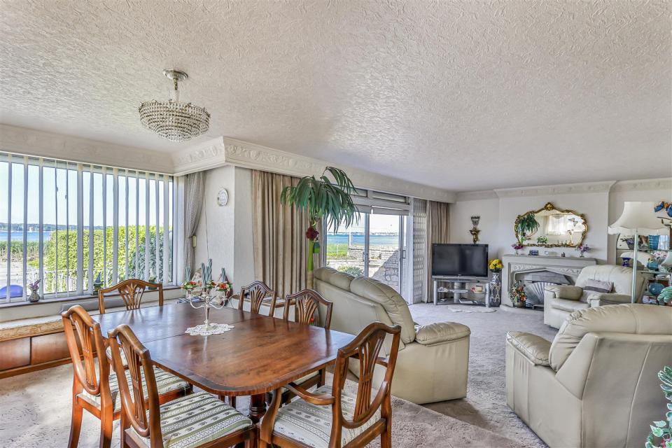 Interior view of a bungalow's dining and living room, overlooking a harbor.