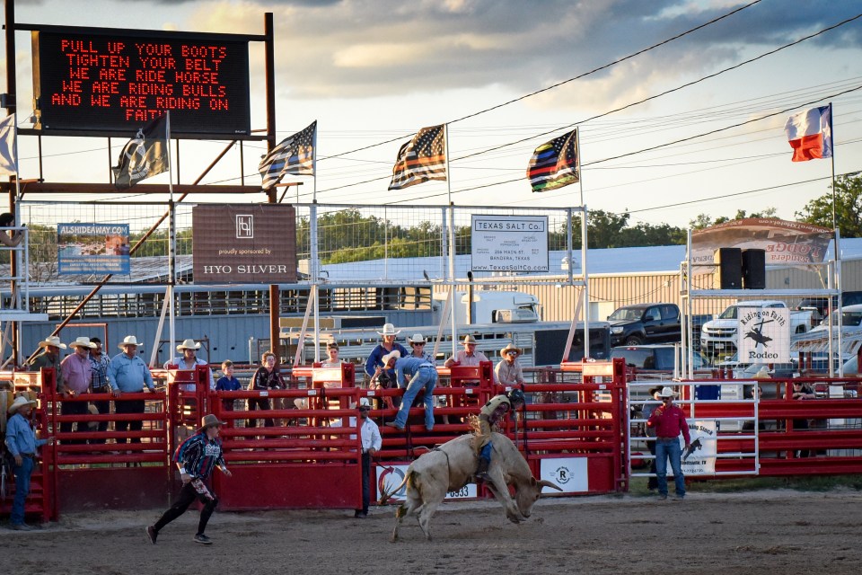 Rodeo bull rider being thrown from bull.