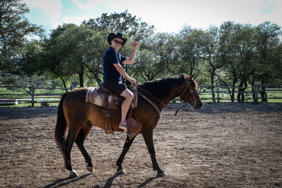 Man in cowboy hat riding a horse.