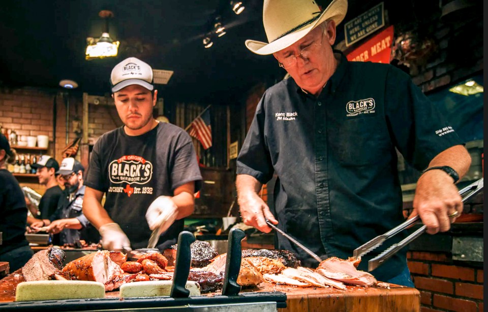 Two men preparing barbecue at Black's Barbecue.