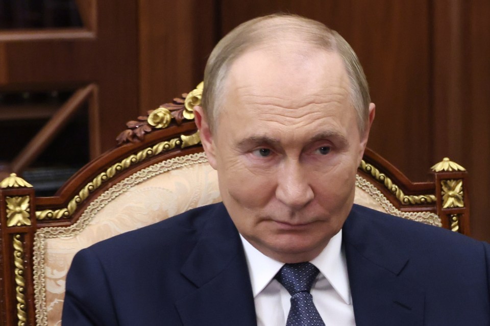 Vladimir Putin listening during a meeting.